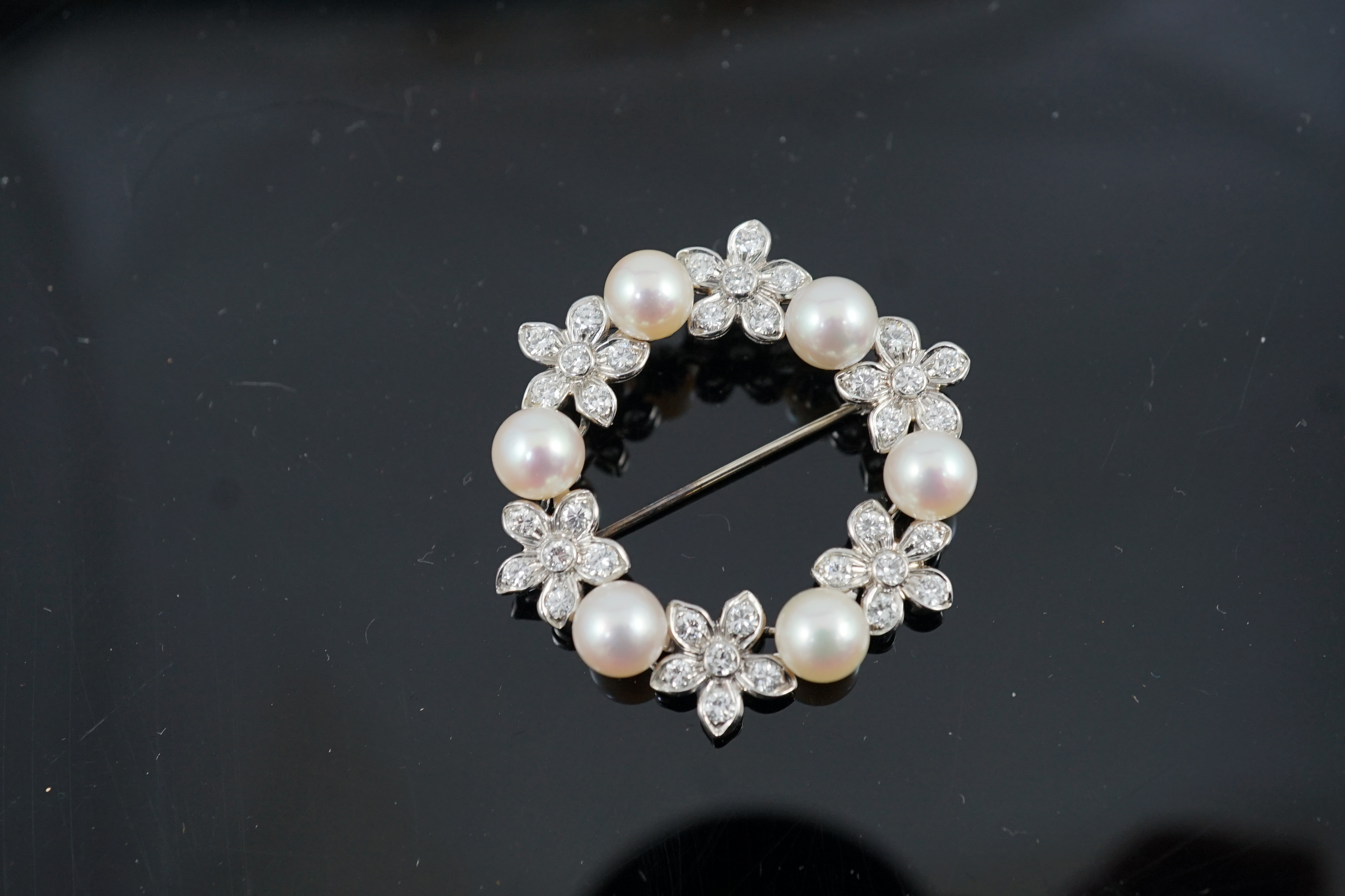 A late 20th century white gold cultured pearl and diamond cluster set openwork circular brooch